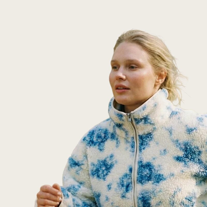 Prio One brand styling: a cut-out portrait of a woman in a blue and cream fleece on a plain background